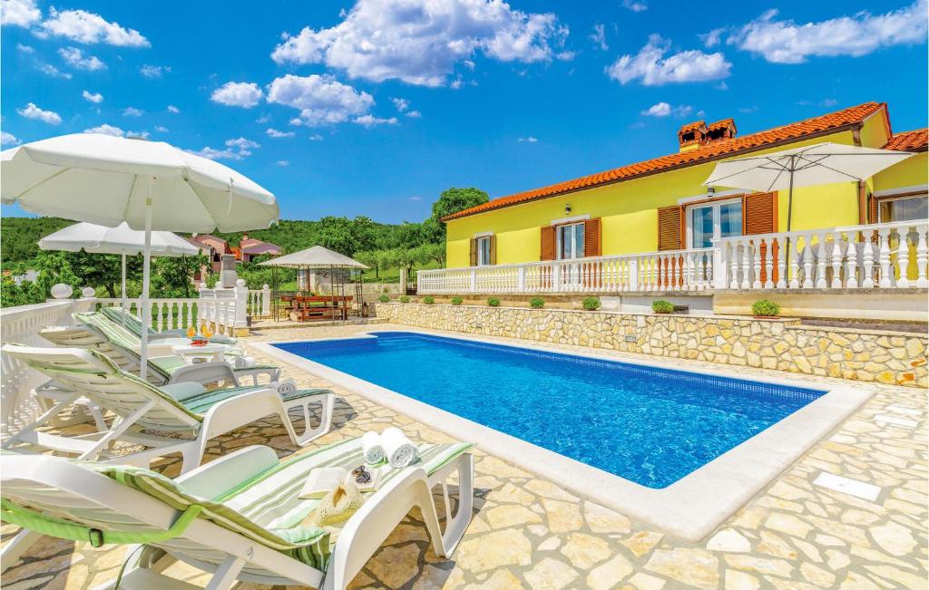 a villa with a swimming pool and patio furniture at Stunning Apartment In Rabac With Kitchen in Rabac