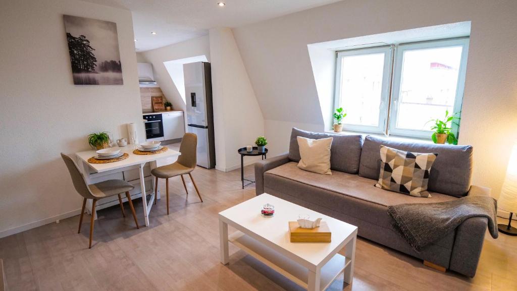 salon z kanapą i stołem w obiekcie # Le 4 # Très beau appartement T3 Neuf, tout confort, Mulhouse centre ville w Miluzie