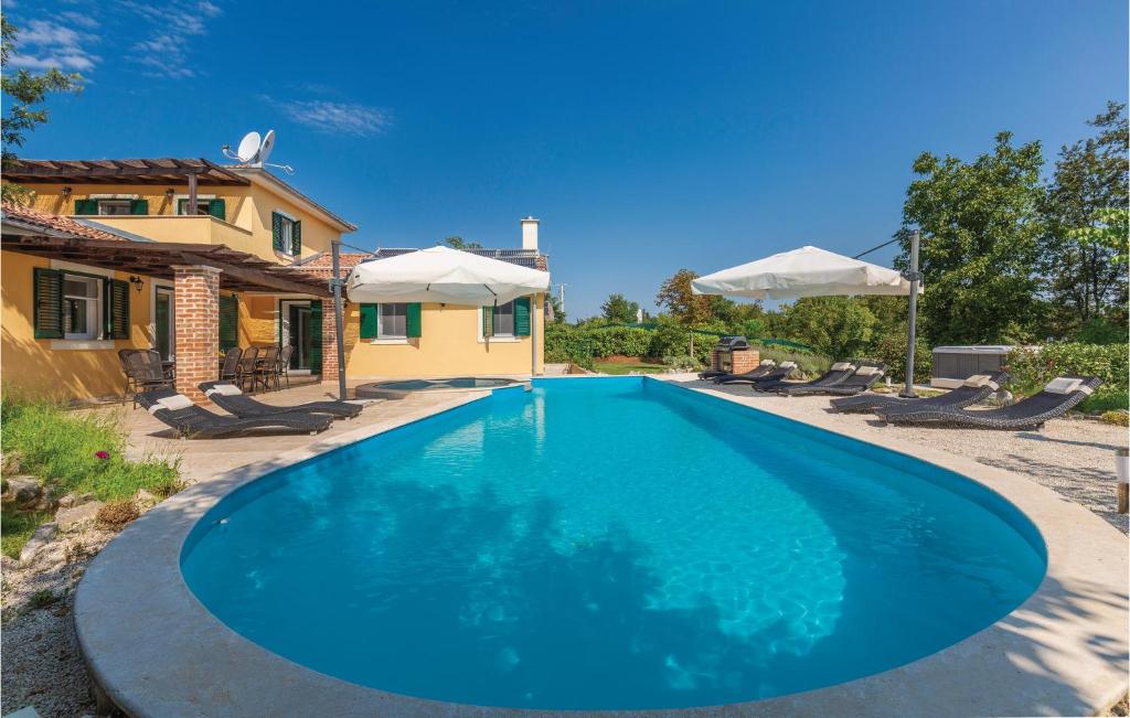 a large blue swimming pool in front of a house at Nice Home In Rezanci With Wifi in Režanci