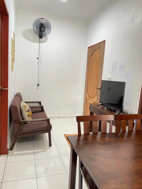 a living room with a chair and a television at D’Aliff Pamalan Homestay Keningau in Keningau