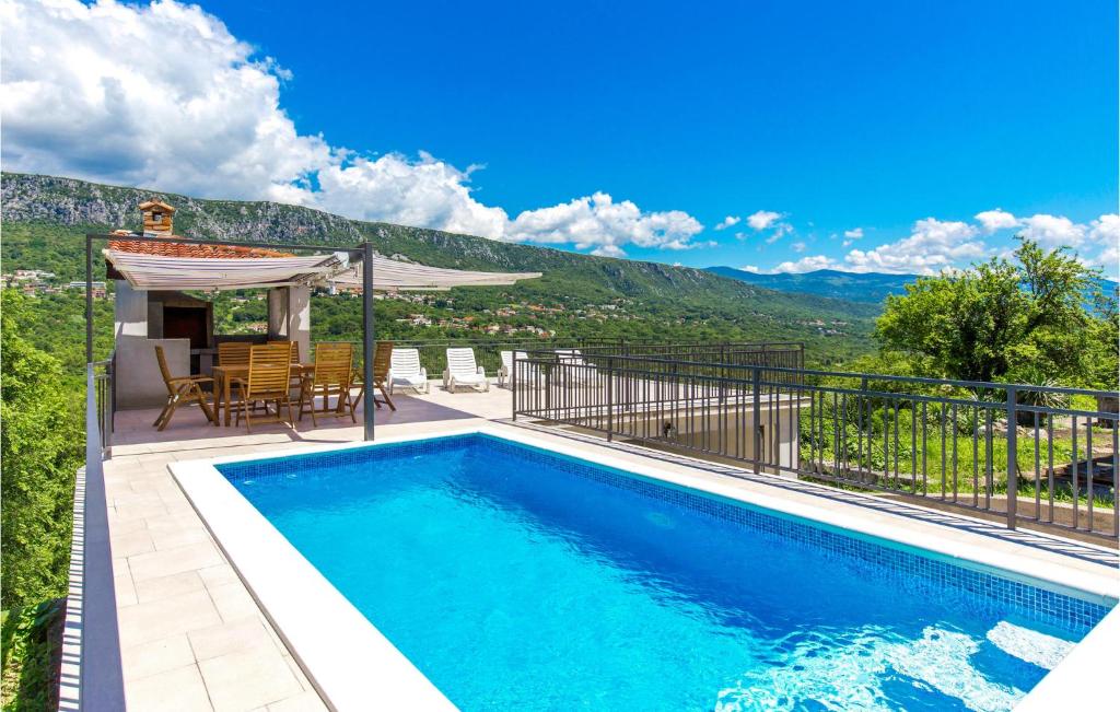 a swimming pool with a table and chairs and a house at Stunning Home In Bribir With Kitchen in Bribir