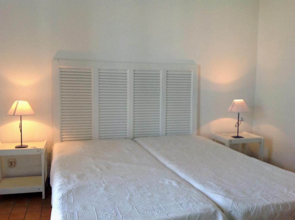 a bedroom with a large white bed and two lamps at Marina sur presqu’île des Capellans (Wifi) 6 couchages in Saint-Cyprien
