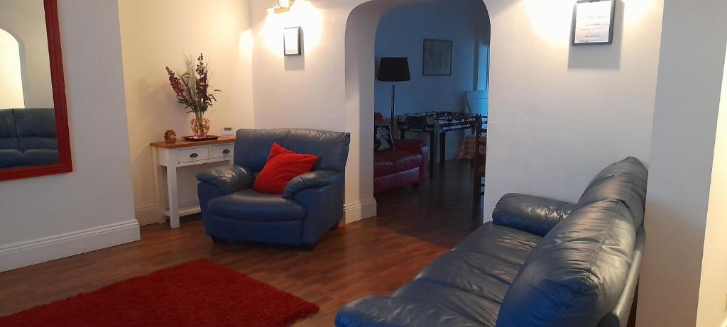 a living room with a leather couch and two chairs at Large countryside home in Tow Law