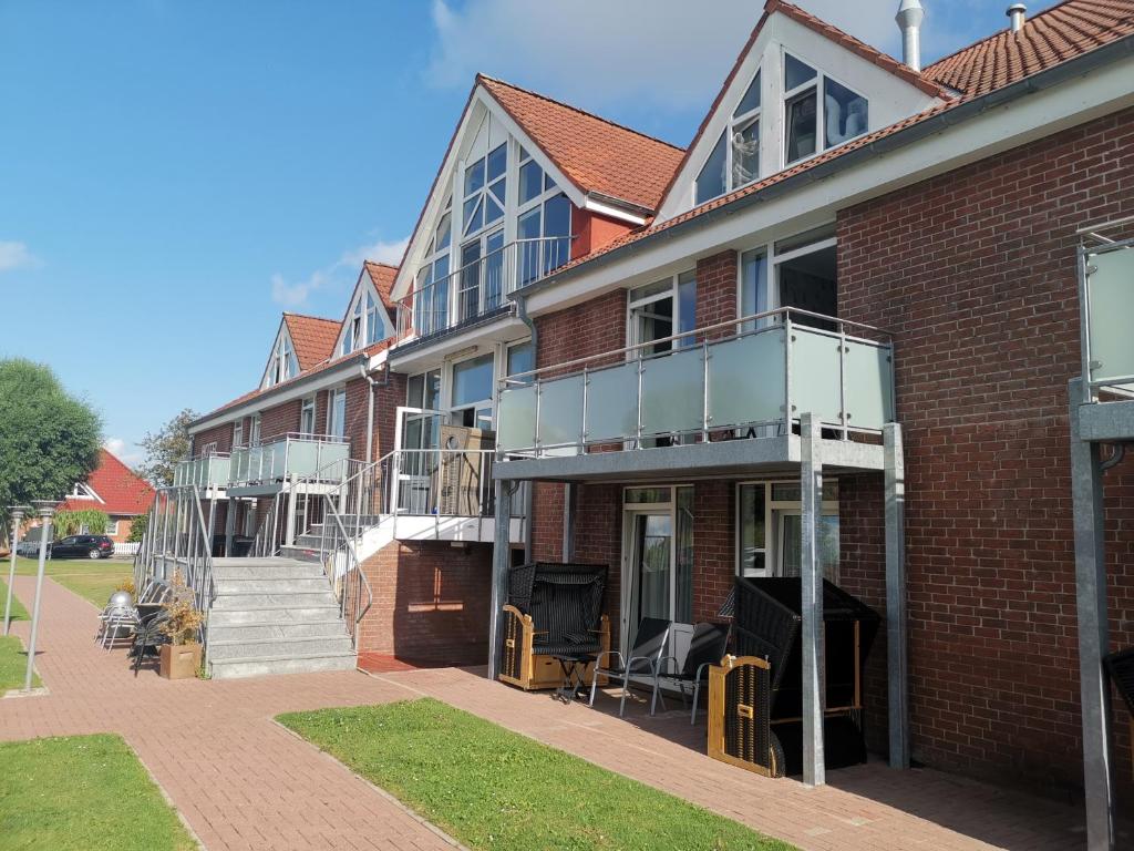 a red brick building with stairs and a balcony at Hotel Aquarius in Norddeich