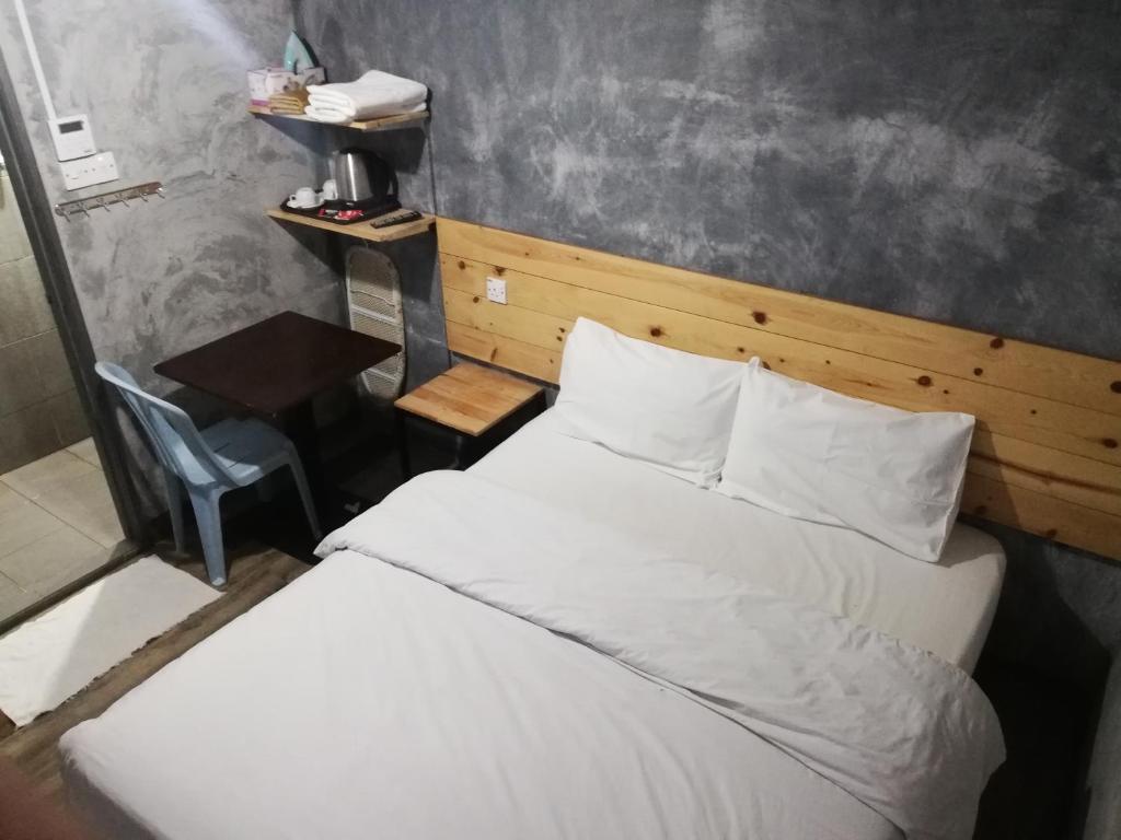 um quarto com uma cama, uma mesa e uma cadeira em Myera Hotel em Banting