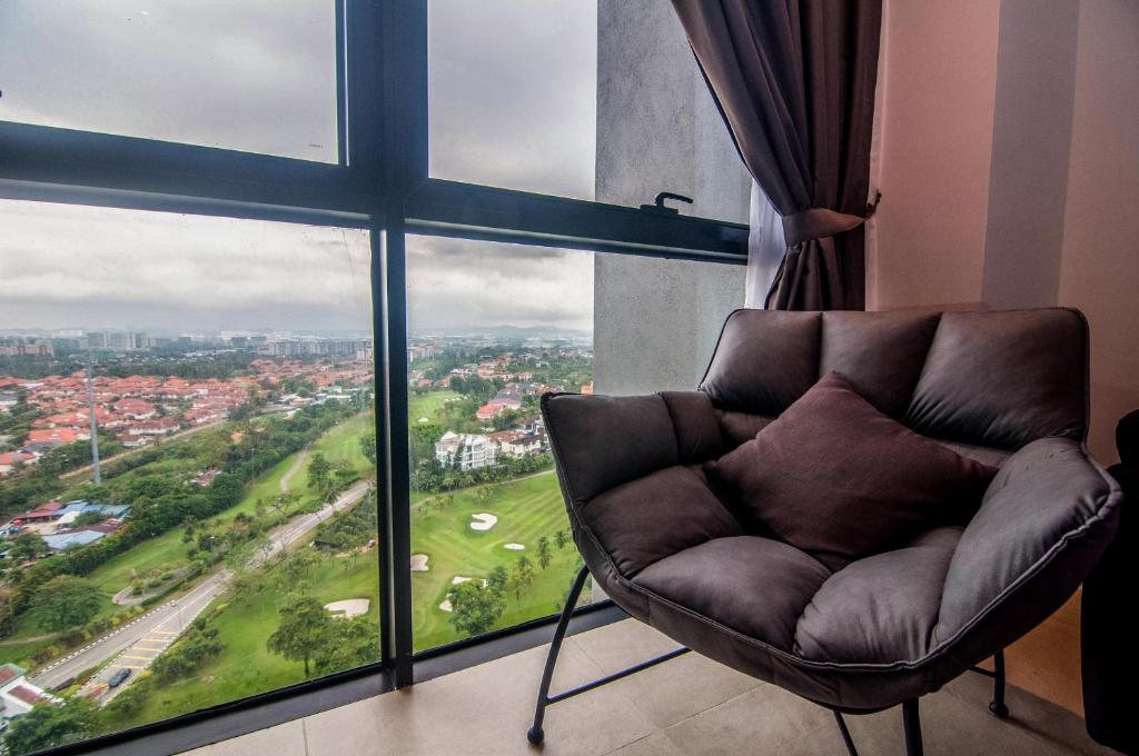 a chair in a room with a large window at Lumi Tropicana - Idealhub in Petaling Jaya