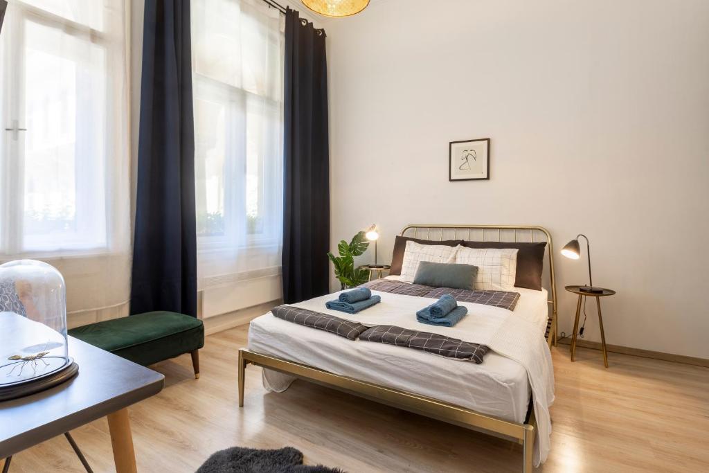 a bedroom with a bed and a table and a chair at Deluxe Downtown Home by Elisabeth in Budapest
