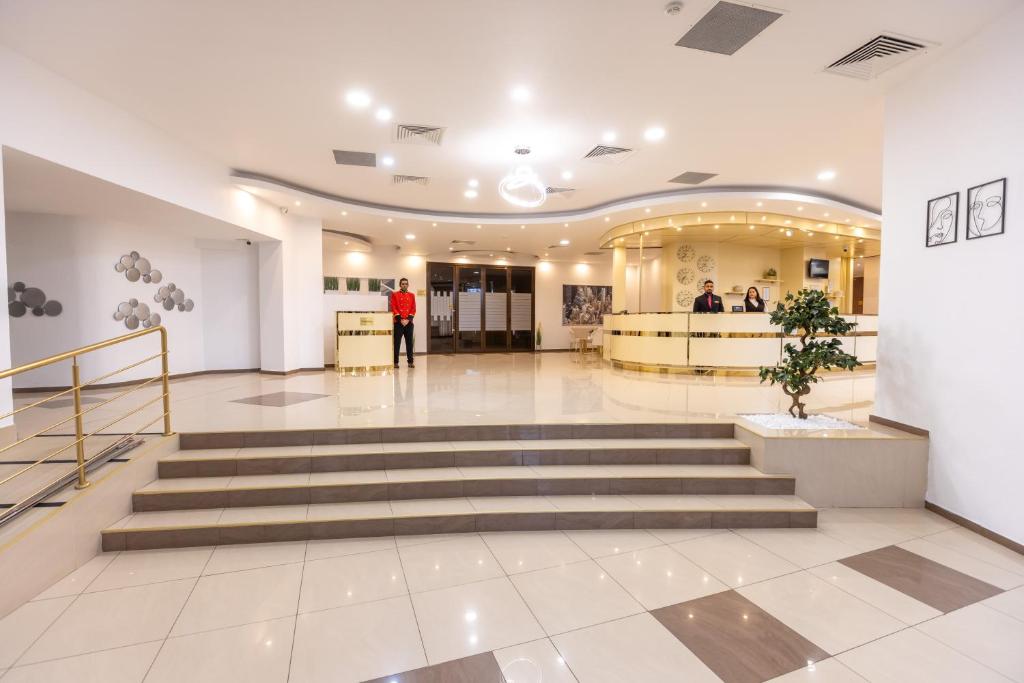 eine Lobby eines Gebäudes mit einer Treppe in der Unterkunft Hotel Sir Royal in Bukarest