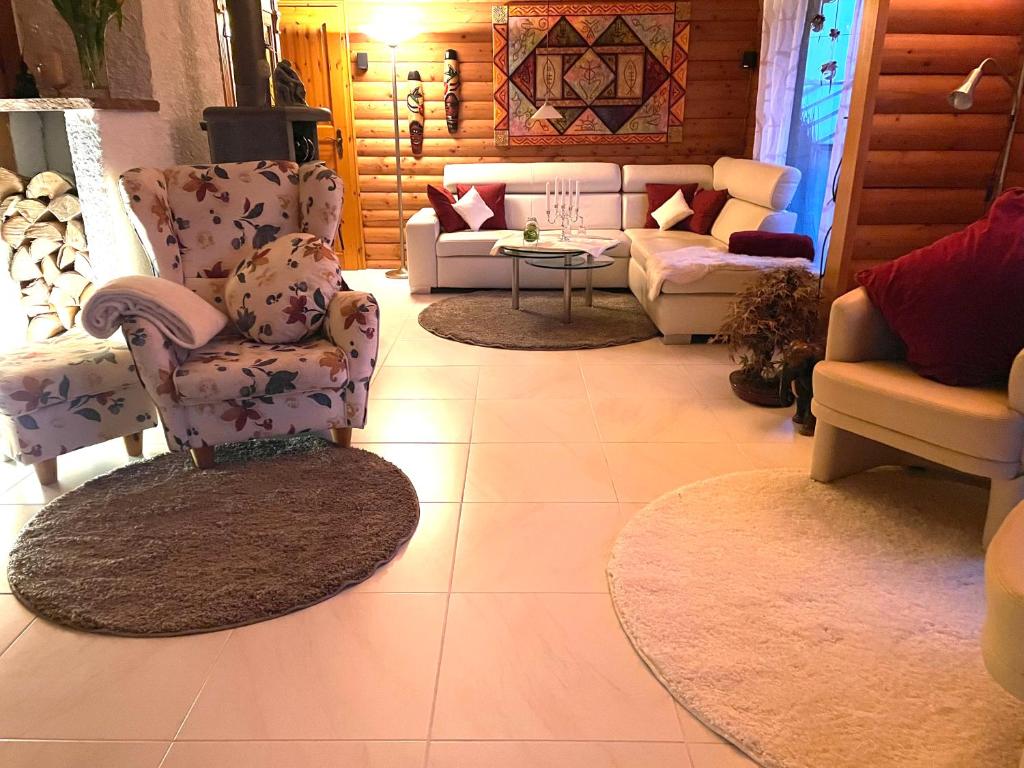 ein Wohnzimmer mit Stühlen, einem Sofa und einem Tisch in der Unterkunft 1000qm, Westerwälder Landhaustraum 