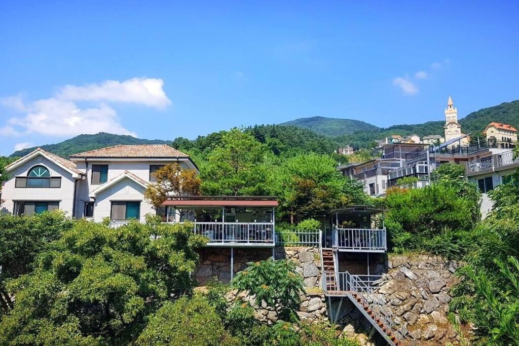 um grupo de casas numa colina com árvores em Gapyeong Casa Swiss Pension em Gapyeong