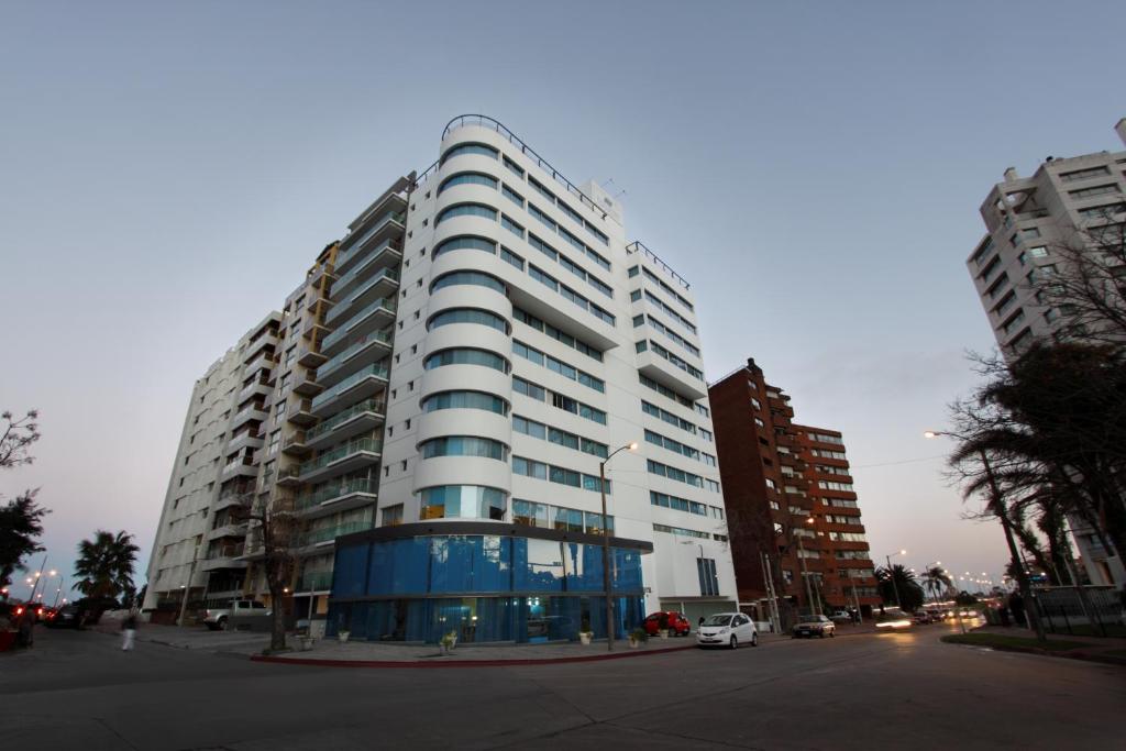 a tall white building with a car parked in front of it at Palladium Business Hotel in Montevideo