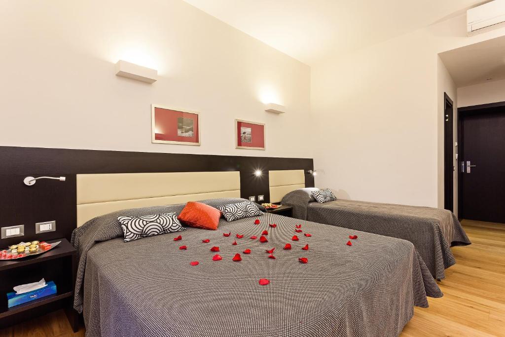1 dormitorio con 2 camas con rosas rojas en la cama en Domus Best Guest House, en Roma