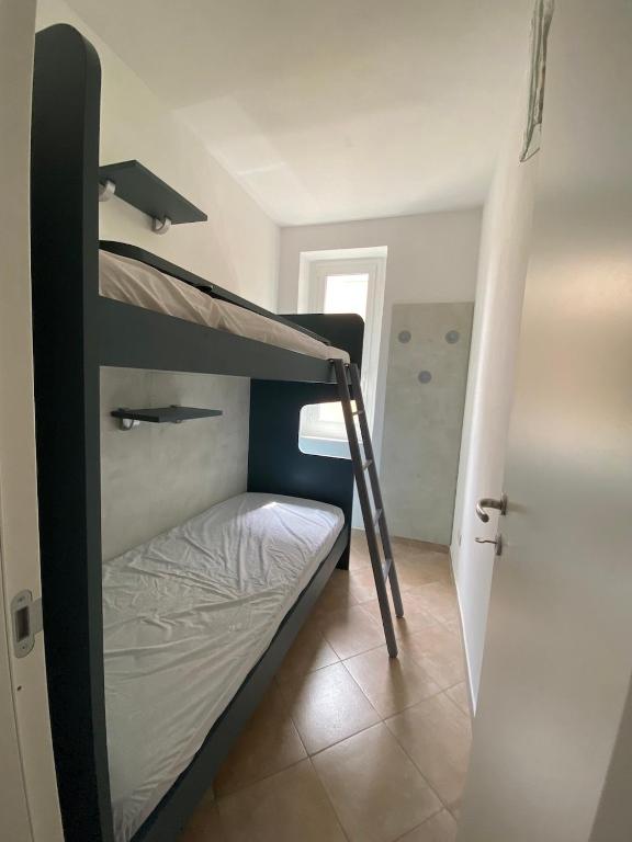 a bedroom with two bunk beds and a door at Luci in San Vincenzo