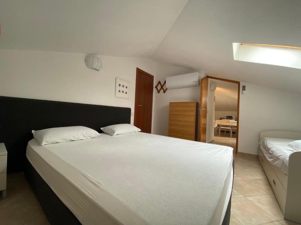 een slaapkamer met een groot wit bed en een spiegel bij Luci in San Vincenzo