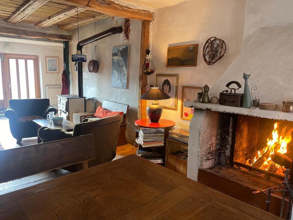 een woonkamer met een open haard met een tafel en een bank bij Das Landhaus in Bachevo