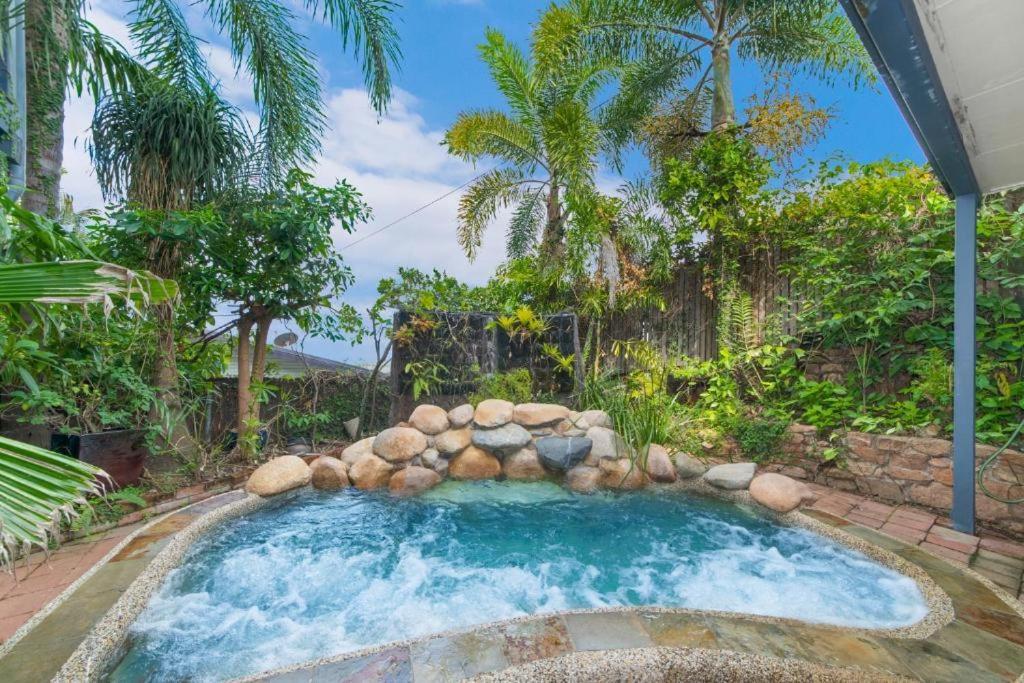 una piscina con una pared de roca y árboles en Denham Heights en Townsville