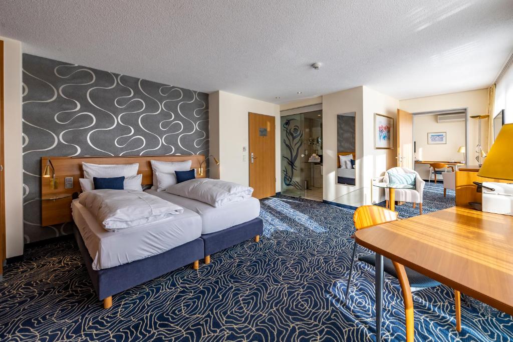 ein Hotelzimmer mit einem Bett und einem Schreibtisch in der Unterkunft Hotel Seehof Haltern am See in Haltern