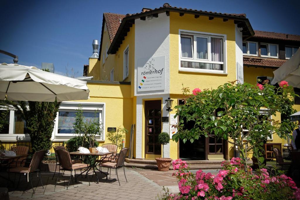 żółty budynek ze stołem przed nim w obiekcie Römerhof w Stuttgarcie