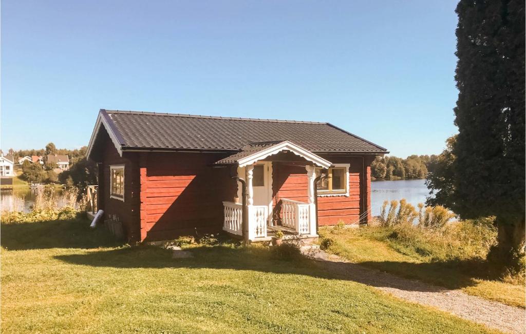 una piccola casa rossa sul lato di un lago di Awesome Home In Borlnge With Wifi a Borlänge