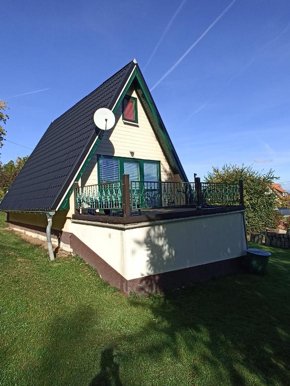 a small house with a balcony with a roof at Bungalow Sud-Harz Bleicherode onder in Bleicherode