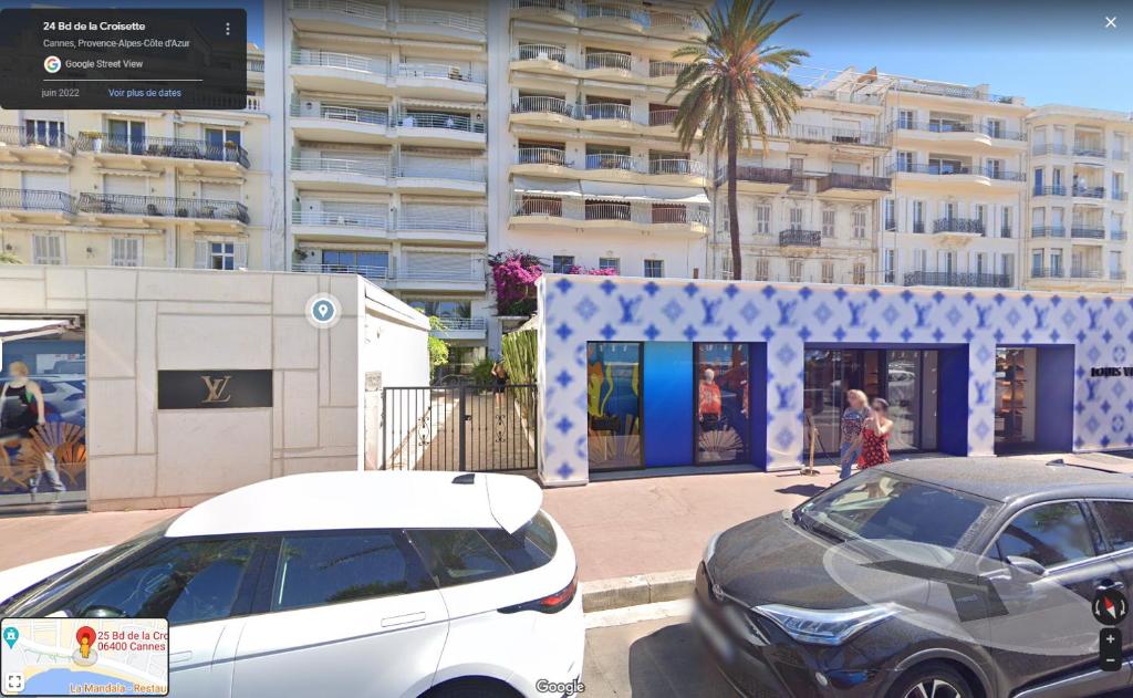 zwei Autos auf einem Parkplatz vor einem Gebäude geparkt in der Unterkunft Lovely 1 Bedroom Boulevard de la Croisette in Cannes