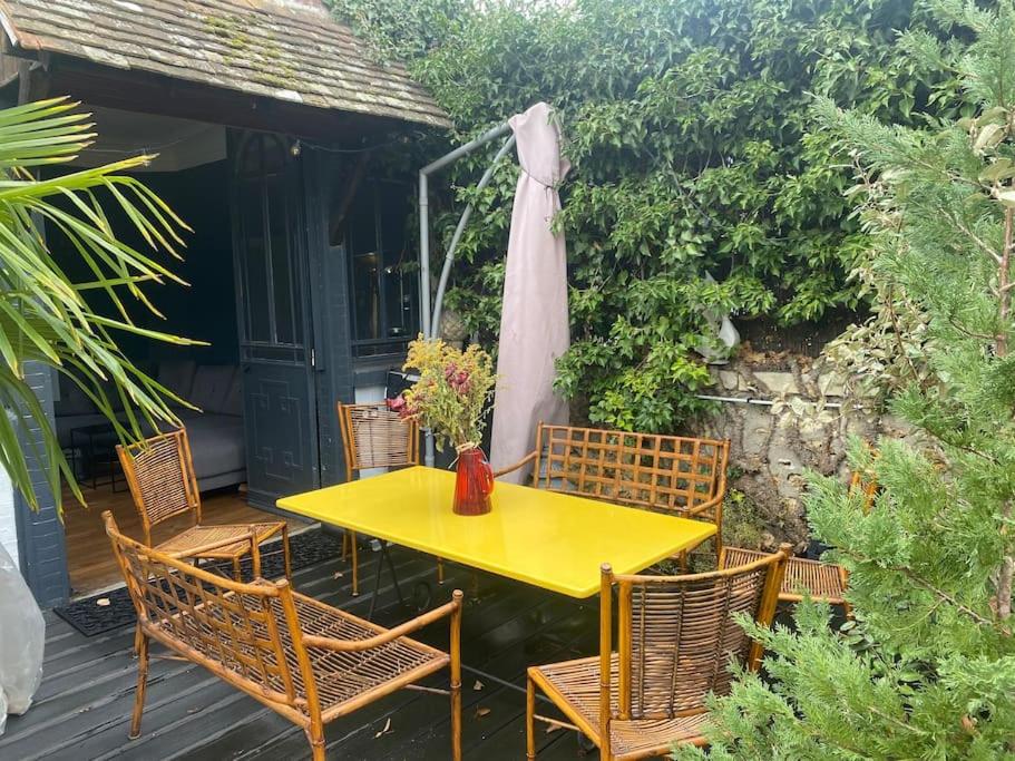 a yellow table and chairs on a patio at Apparte Vesinet rdc terrasse jardin in Le Vésinet