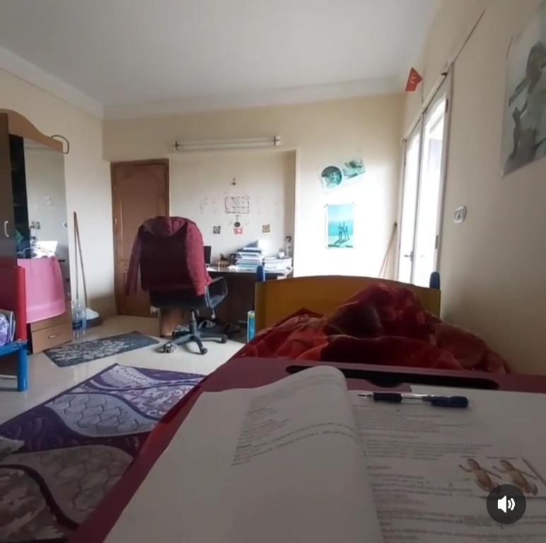 a room with a bed with a book and a desk at شقة مميزة في وسط بورسعيد 