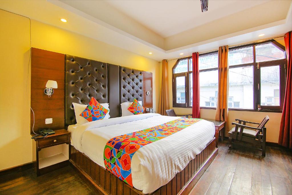 a bedroom with a large bed and some windows at FabHotel Dwaper in Mussoorie
