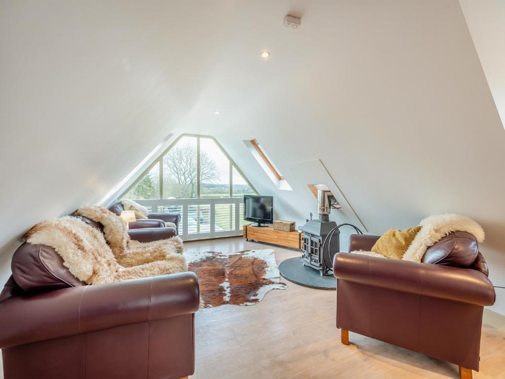 a living room with two couches and a large window at The Studio in Woolland