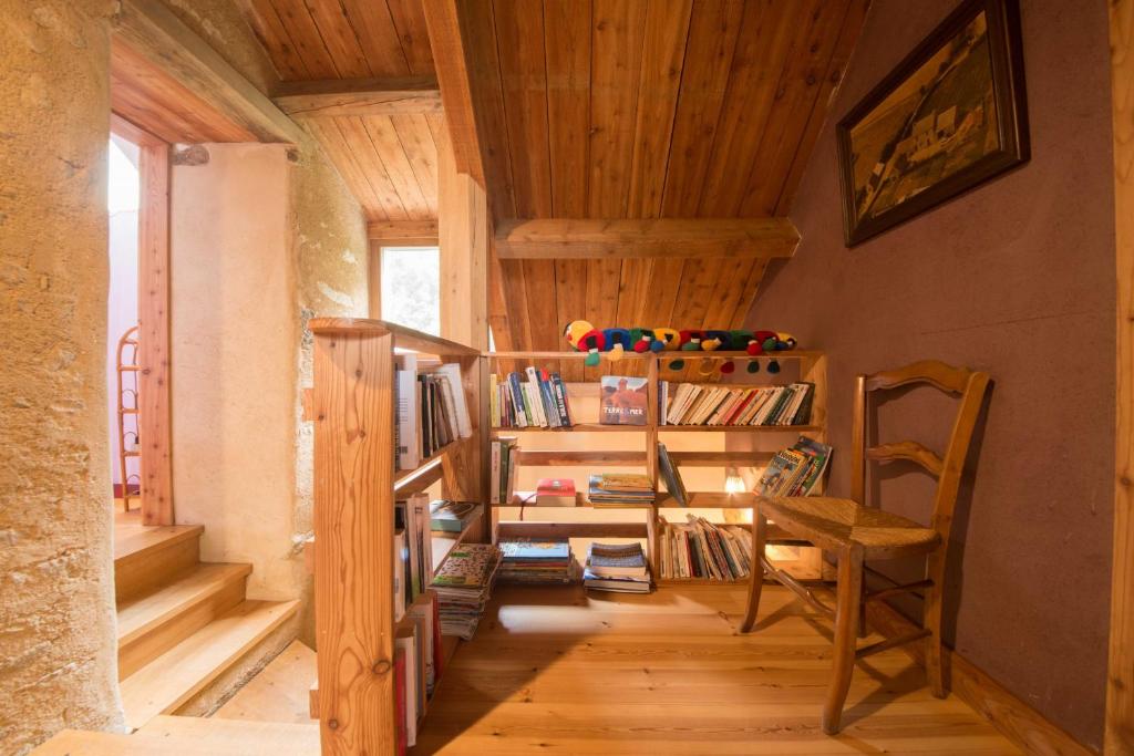 a room with a staircase with a chair and books at MAISON YUKTI - Magnifique maison de charme proche plage in Lampaul-Ploudalmézeau