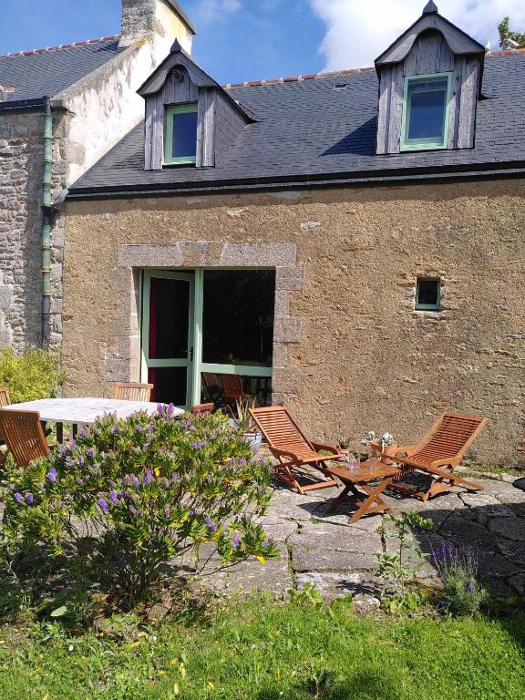 two chairs and a table in front of a building at MAISON YUKTI - Magnifique maison de charme proche plage in Lampaul-Ploudalmézeau