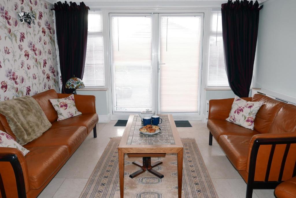 a living room with two leather couches and a coffee table at The Tides in Cleethorpes