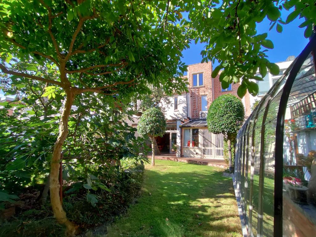 una vista desde el jardín de una casa con un árbol en Bed & Breakfast Exterlaer, en Amberes