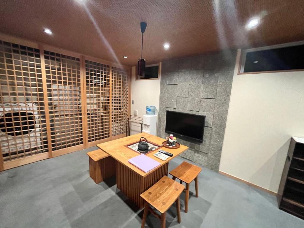 a living room with a table and a tv at Yanaka Kotobuki Sou in Tokyo