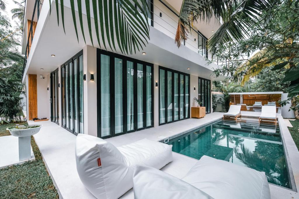 uma casa com piscina e mobiliário branco em Terra Villas em Ahangama