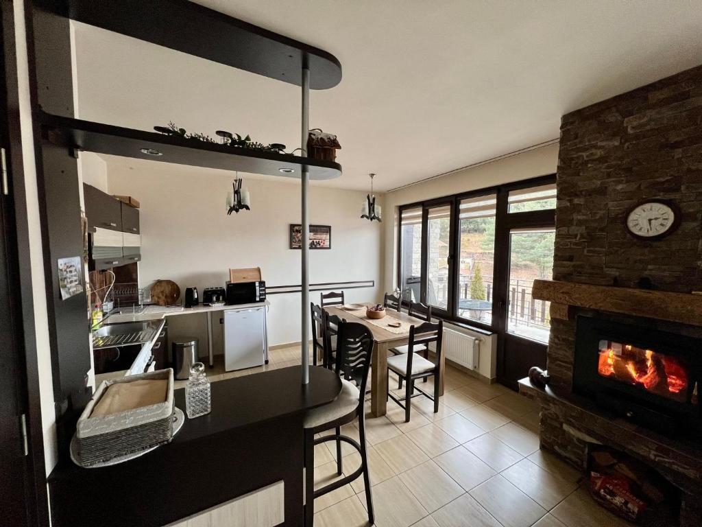 a kitchen and a living room with a fireplace at Rodopski Ailyak in Dospat