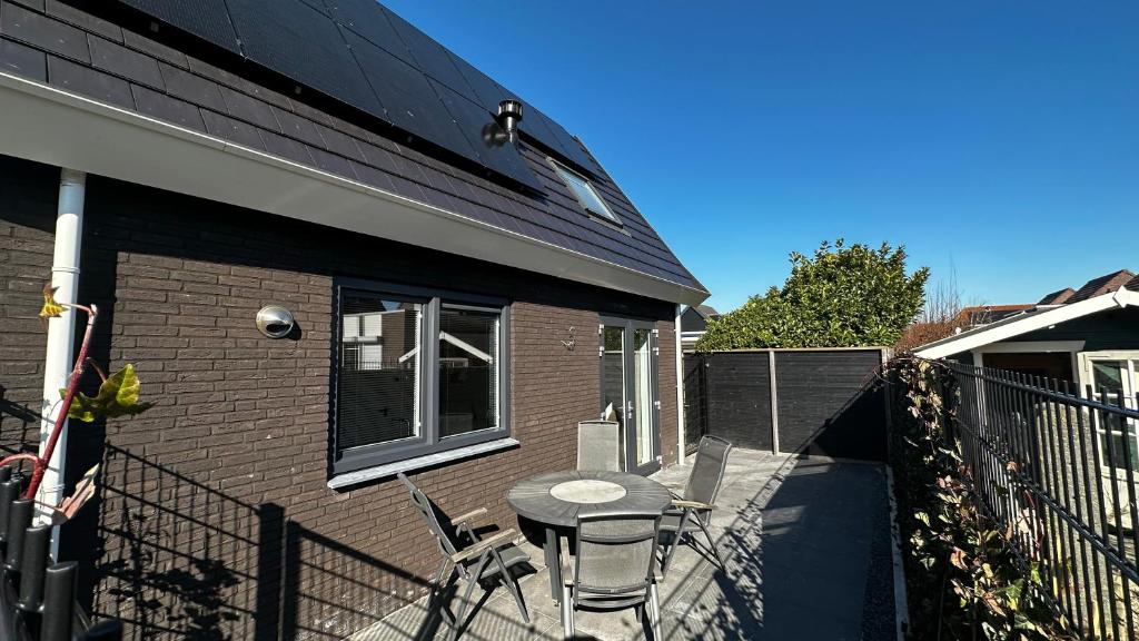 une terrasse avec une table et des chaises à côté d'une maison dans l'établissement ' Zilten Huus Zoutelande, à Zoutelande