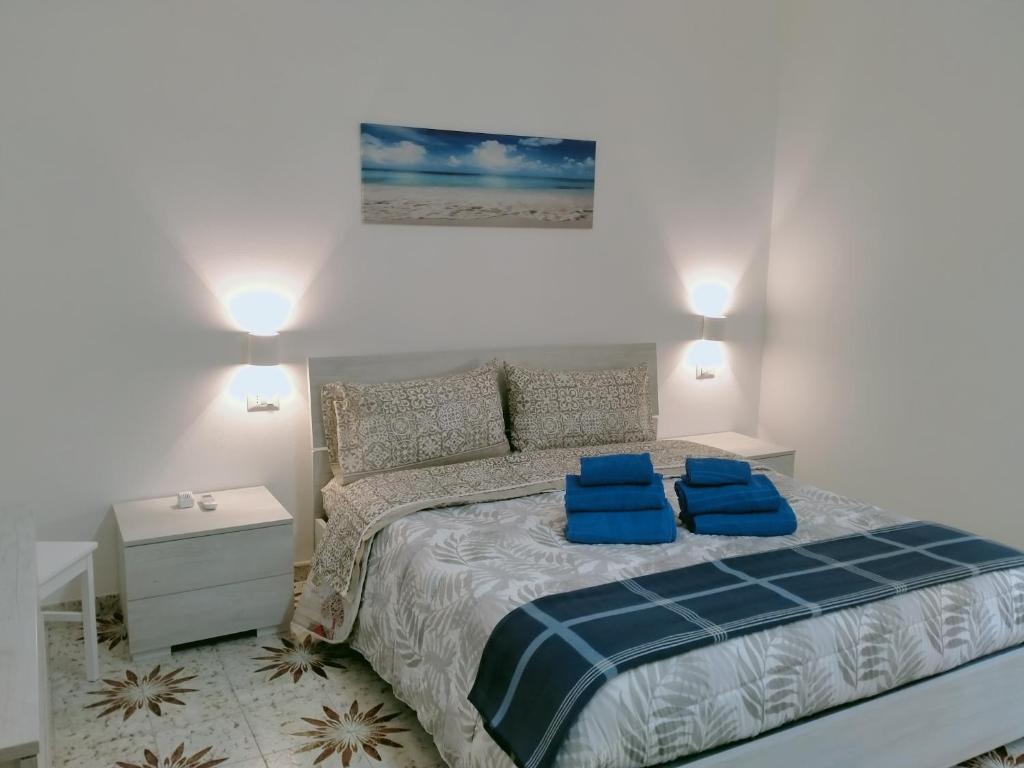 una camera da letto con un letto con due cuscini blu sopra di Le Camelie appartamento a Bosa