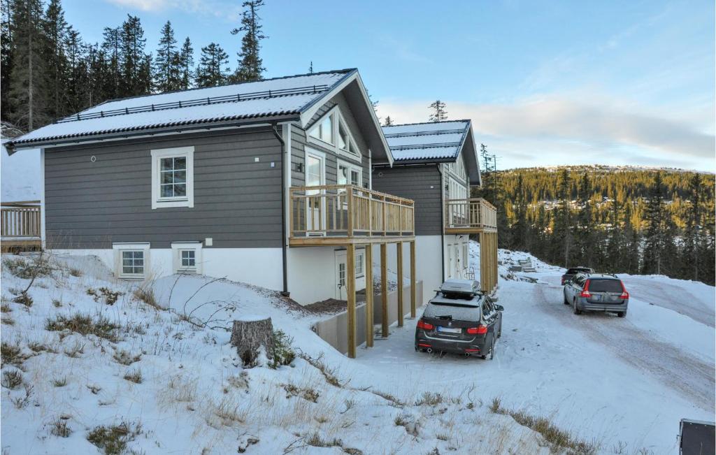 Una casa con coches aparcados frente a ella en la nieve en Stunning Home In Slen With Kitchen, en Sälen