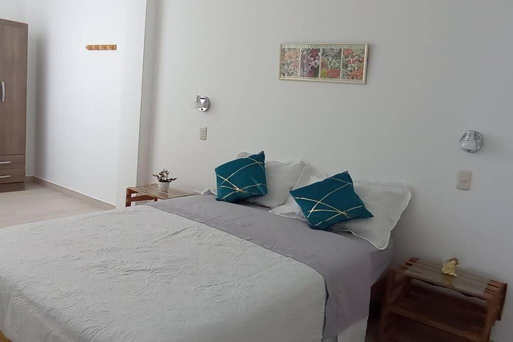 - une chambre avec un grand lit et des oreillers bleus dans l'établissement Malabrigo's House - On Puerto Chicama Dpto II, à Puerto Chicama