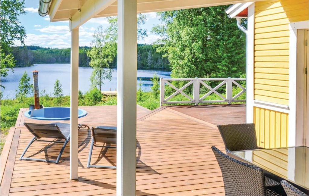 a wooden deck with a table and chairs on a house at Beautiful Home In Sunne With 2 Bedrooms, Jacuzzi And Wifi in Älvsätern