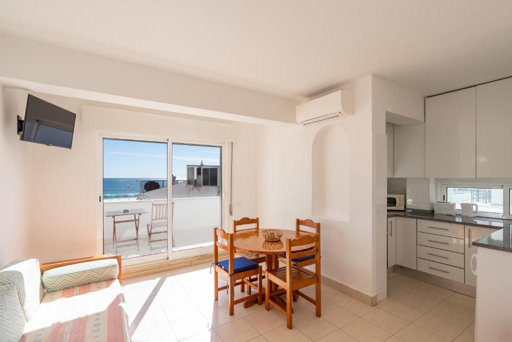 a kitchen and living room with a table and chairs at Edifício Sequeira - Alojamento Local by Umbral in Albufeira