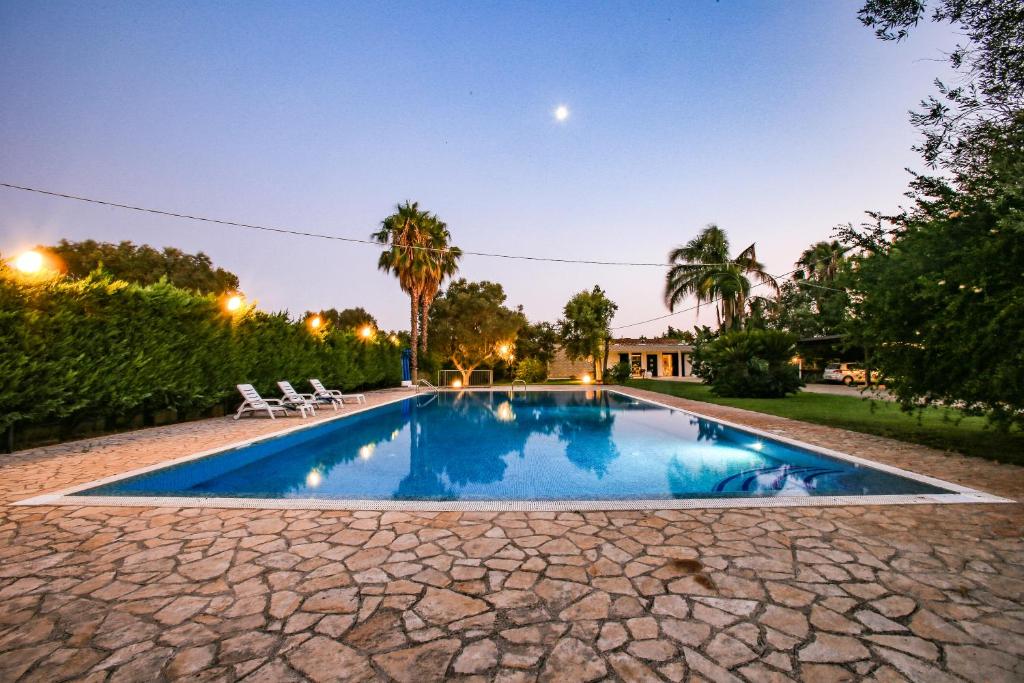 uma piscina no quintal de uma casa à noite em Villa con parco e piscina em San Michele Salentino