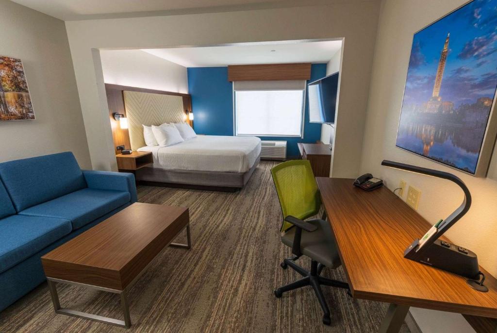 une chambre d'hôtel avec un lit, un canapé et un bureau dans l'établissement Wingate by Wyndham Lafayette Airport, à Lafayette