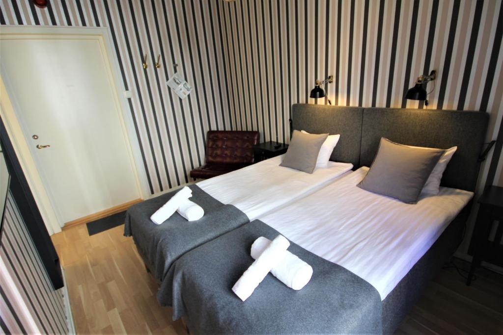 een slaapkamer met een groot bed met twee witte kruisen erop bij Vattengrändens Vandrarhem & Hotel in Norrköping