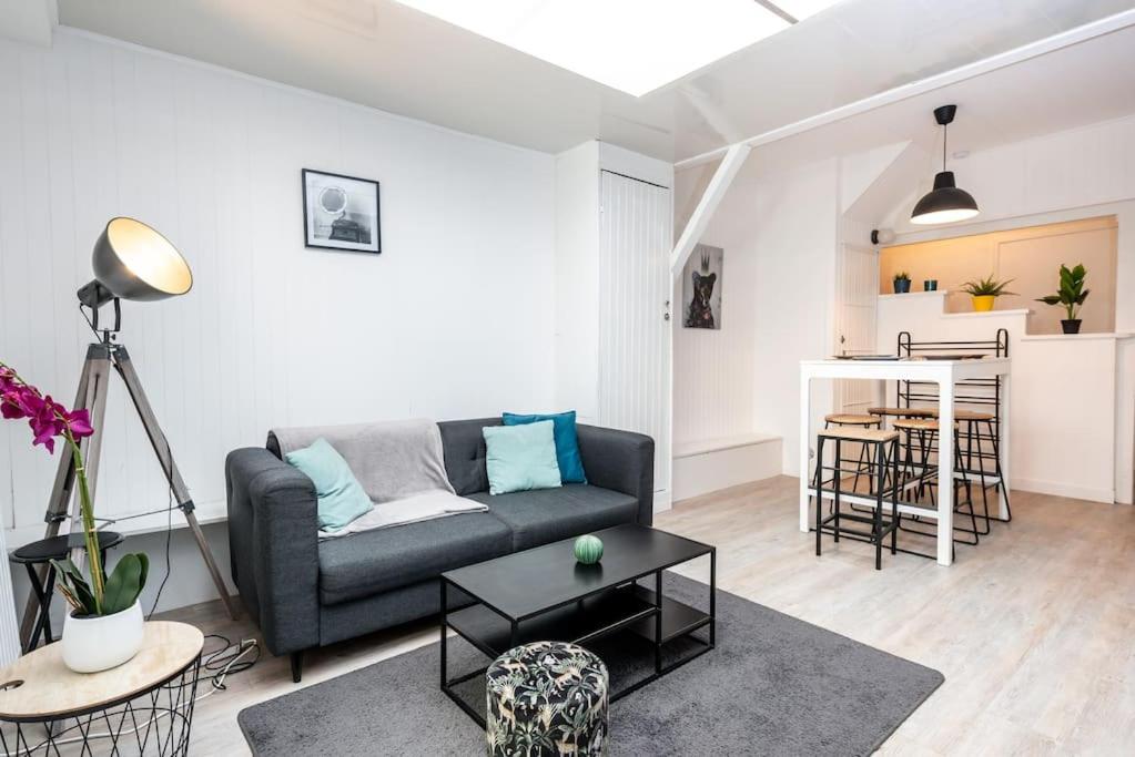 un salon avec un canapé et une table dans l'établissement Le saint honoré, à Amiens