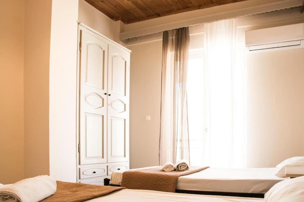 a bedroom with two beds and a window at Margaret Apartments in Lefkimmi