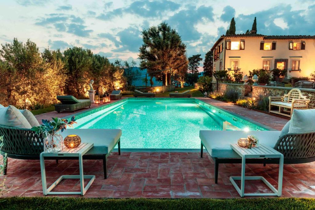 - une piscine avec 2 tables et des chaises à côté d'une maison dans l'établissement Villa Il Castello, à San Quirico di Moriano
