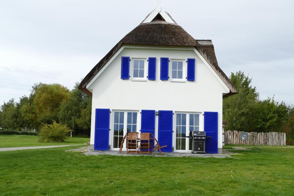 uma casa azul e branca com um telhado de gambrel em Hus Tina Rügen em Trent