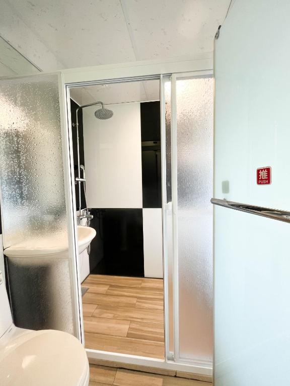 a bathroom with a shower and a toilet and a refrigerator at Cen Pin B&amp;B in Jiufen